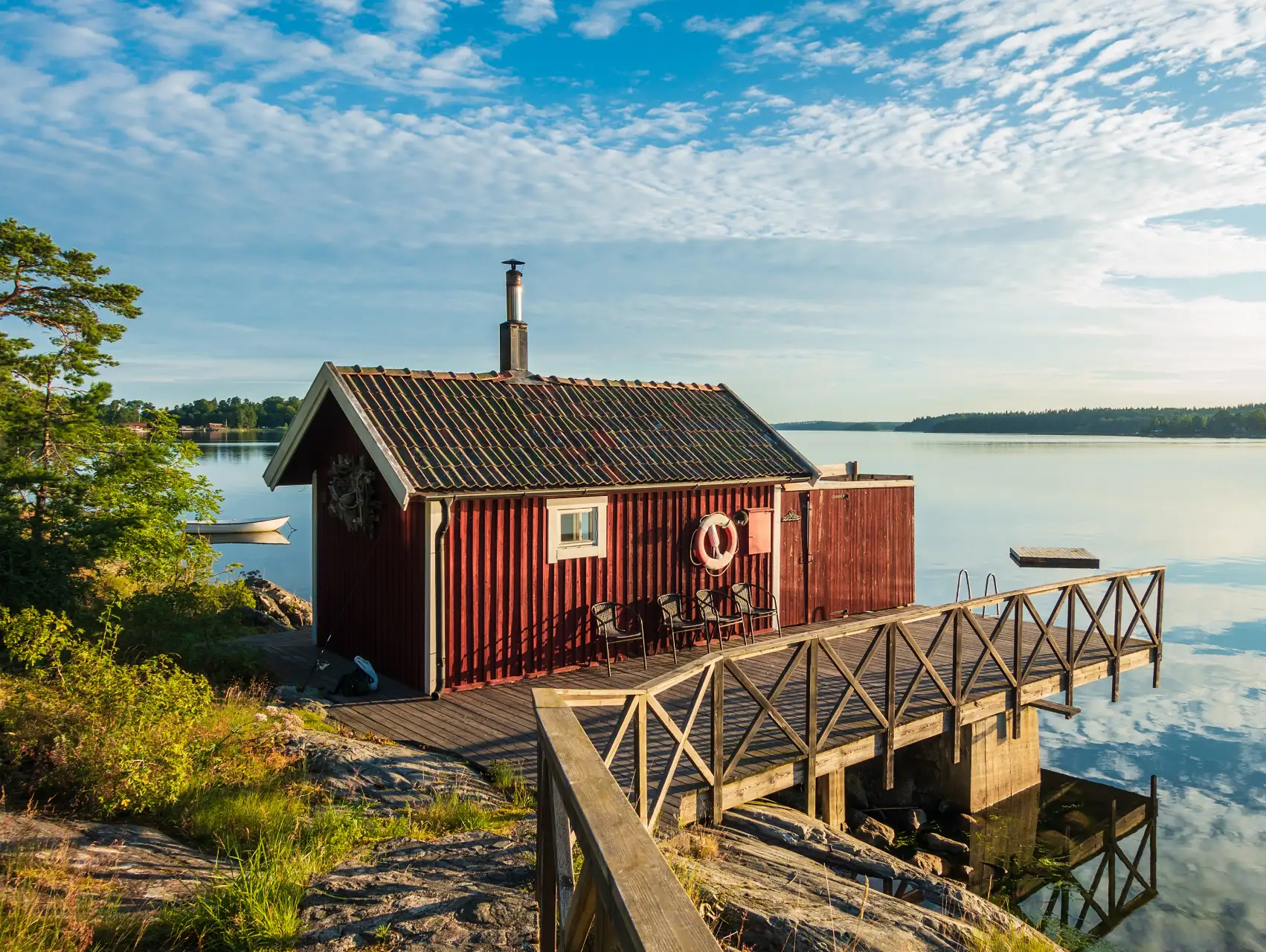 Röd stuga vid vattnet